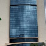 Edifício do Tribunal de Justiça do DF em Brasília com bandeiras a meio mastro, representando luto pela morte de desembargador.