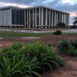 Edifício do TJDFT em Brasília com bandeiras a meio mastro, representando luto pela morte do desembargador Maurício Miranda.