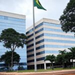 Fachada do Tribunal de Justiça do Distrito Federal em Brasília com bandeiras a meio mastro, simbolizando luto.