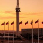 Torre de TV em Brasília com bandeiras venezuelanas ao fundo, representando celebração de exilados pela prisão de Maduro.
