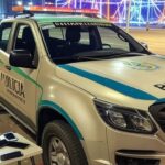 Viaturas policiais em rua de Brasília no Carnaval, com confetes e sacola de celulares furtados, cena de prisão familiar.