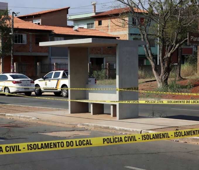 Parada de ônibus em Planaltina com fita de isolamento e viatura da Polícia Civil do DF, em cena de investigação.