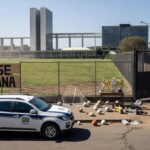 Viaturas policiais do DF estacionadas em evento esportivo em Brasília, ilustrando desperdício de recursos em olimpíadas da segurança pública.