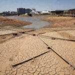 Tubulações de esgoto danificadas em rua de Brasília, ilustrando crise de saneamento no DF com expansão tardia de redes.