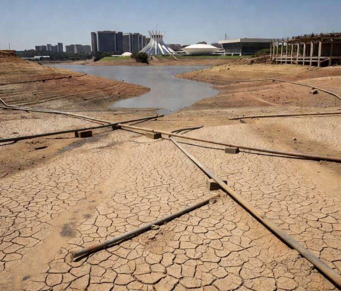 Tubulações de esgoto danificadas em rua de Brasília, ilustrando crise de saneamento no DF com expansão tardia de redes.