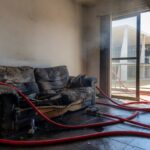 Sala de casa em Brasília com sofá incendiado após discussão doméstica.