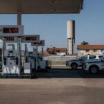 Viatura da Polícia Federal em posto de gasolina investigando aumentos abusivos nos preços dos combustíveis no Brasil.