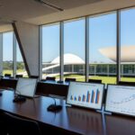 Sala de conferências em Brasília com vista para o Congresso, representando debate sobre desafios do ECA Digital.