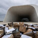 Edifício da Câmara Legislativa do DF sob céu nublado, com documentos deteriorados, expondo falhas na gestão pública.