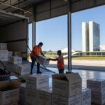 Caixas de vacinas contra Covid-19 descarregadas em aeroporto de Brasília, representando remessa do Ministério da Saúde.