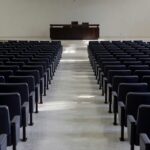 Plenário da Câmara do DF vazio com jaleco de enfermeiro, simbolizando homenagem sem discutir salários